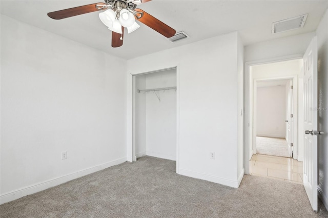 unfurnished bedroom featuring light colored carpet, ceiling fan, and a closet