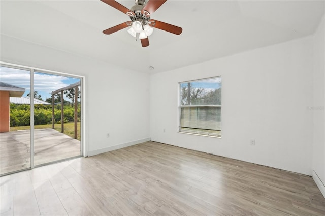 empty room featuring ceiling fan, a healthy amount of sunlight, and light hardwood / wood-style floors