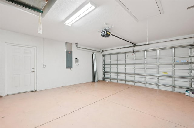 garage with a garage door opener and electric panel