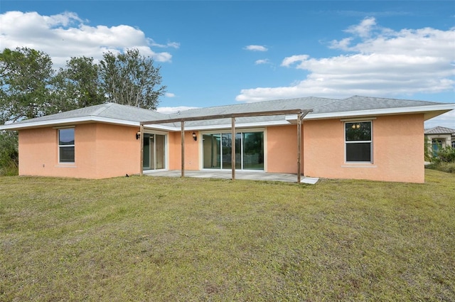 back of house featuring a patio area and a lawn