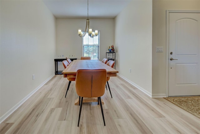 dining space with a chandelier and light hardwood / wood-style flooring