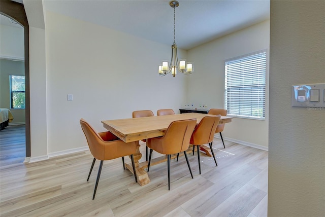 dining area with an inviting chandelier and light hardwood / wood-style flooring