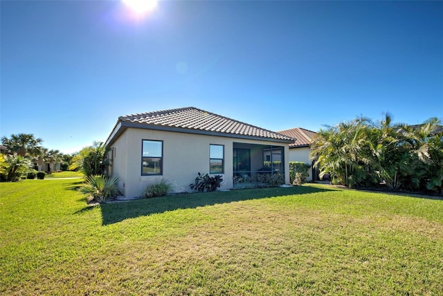 rear view of property featuring a lawn
