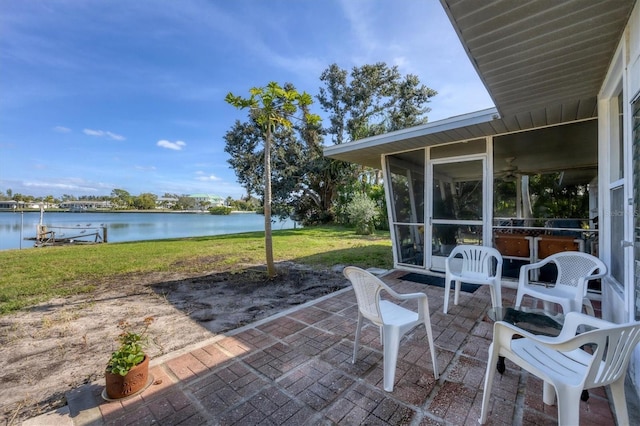 view of patio featuring a sunroom and a water view