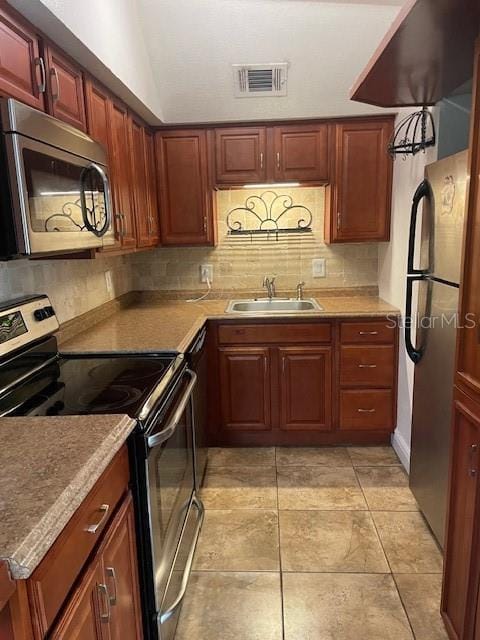 kitchen with tasteful backsplash, sink, light tile patterned floors, and stainless steel appliances