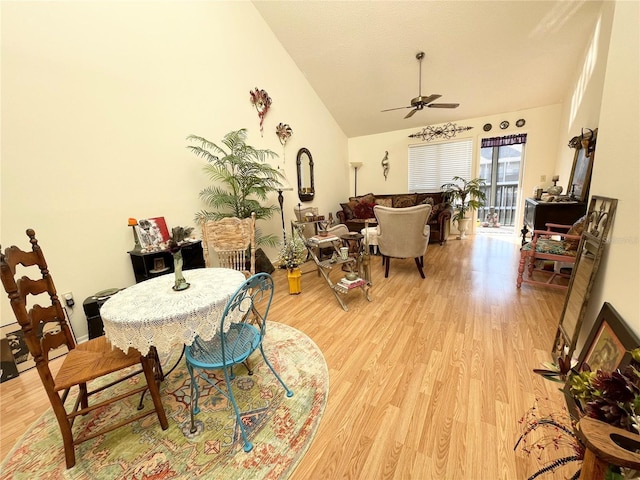 dining space featuring ceiling fan, lofted ceiling, and light wood-type flooring