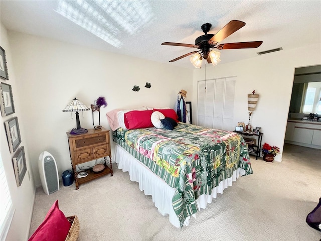 bedroom featuring ceiling fan, carpet floors, a textured ceiling, and a closet