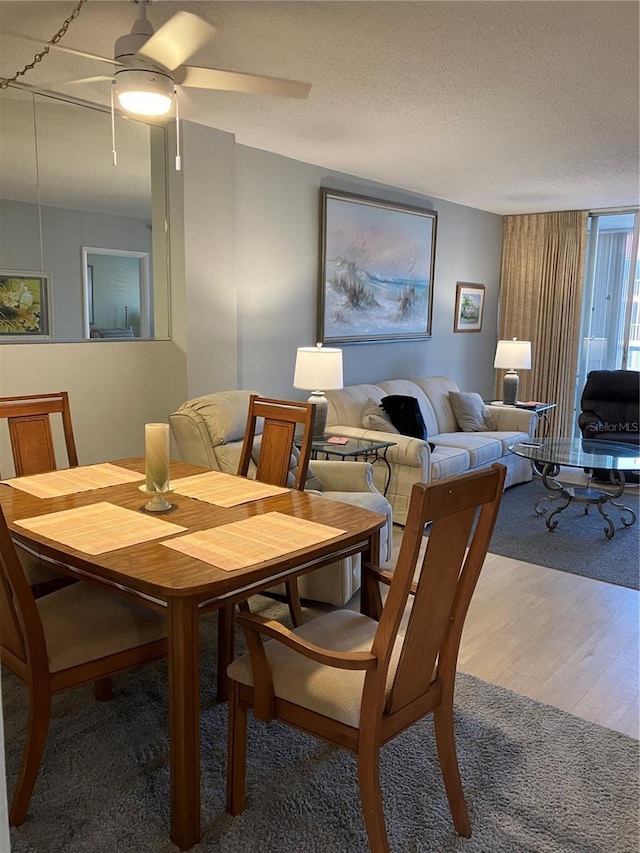 dining room featuring a textured ceiling, ceiling fan, and hardwood / wood-style flooring