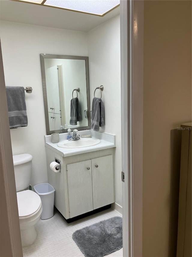 bathroom featuring vanity, tile patterned flooring, and toilet