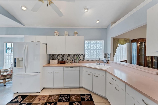 kitchen featuring sink, tasteful backsplash, light tile patterned floors, white appliances, and white cabinets