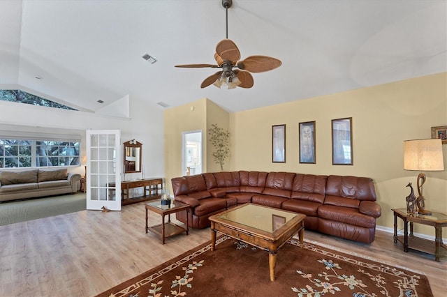 living room with hardwood / wood-style flooring, french doors, ceiling fan, and vaulted ceiling