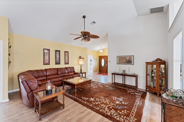 living room with lofted ceiling, light wood-type flooring, and ceiling fan