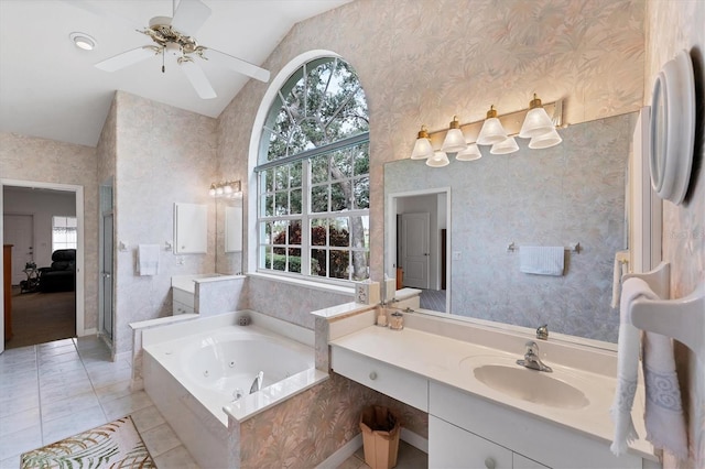 bathroom with lofted ceiling, ceiling fan, vanity, a bath, and tile patterned floors