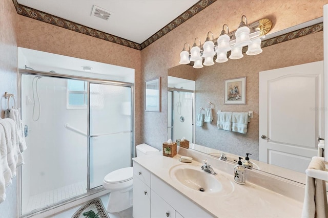 bathroom with vanity, an enclosed shower, and toilet