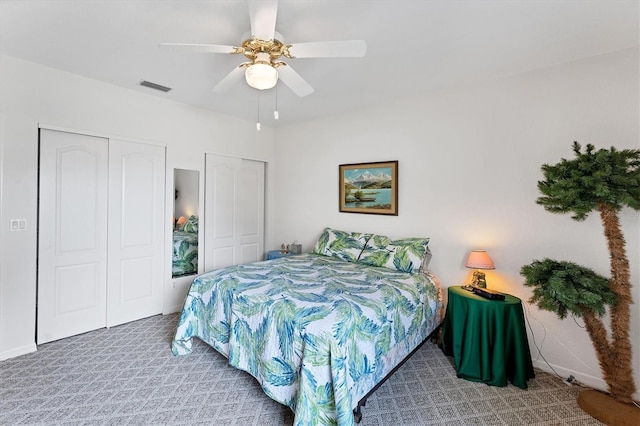 carpeted bedroom featuring two closets and ceiling fan