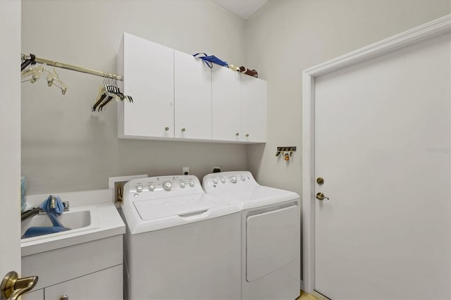 laundry area featuring washer and dryer, sink, and cabinets