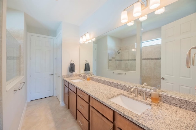 bathroom with tile patterned flooring, a tile shower, and vanity