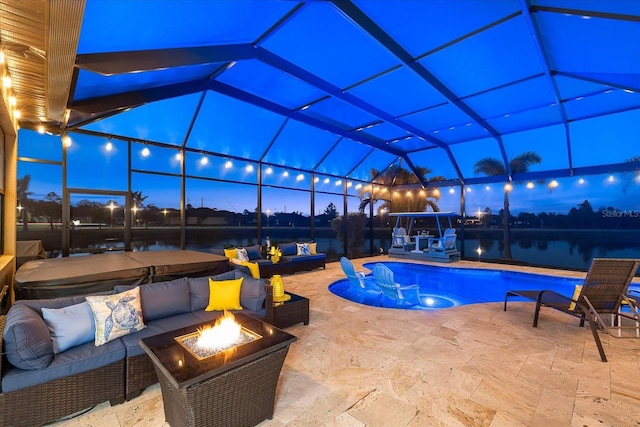 pool at dusk featuring a patio area, an outdoor living space with a fire pit, glass enclosure, a hot tub, and a water view