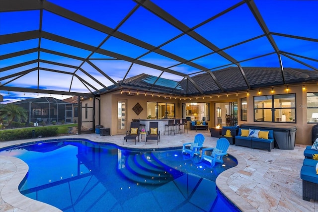 pool at dusk featuring a lanai, an outdoor living space, and a bar