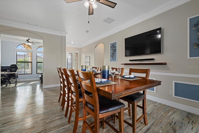 dining space with ceiling fan, crown molding, and hardwood / wood-style flooring