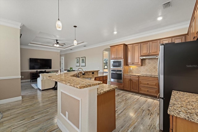 kitchen with stainless steel appliances, an island with sink, hanging light fixtures, ceiling fan, and crown molding