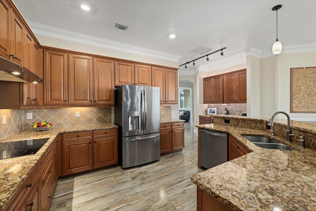 kitchen featuring decorative light fixtures, stainless steel appliances, sink, rail lighting, and light stone counters