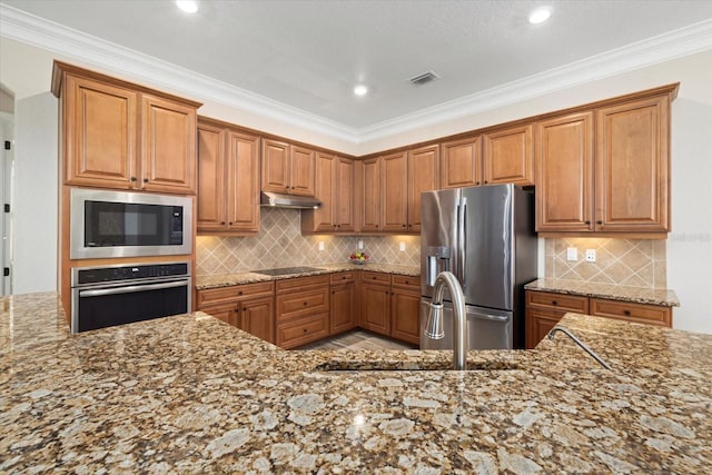 kitchen with light stone counters, appliances with stainless steel finishes, and crown molding