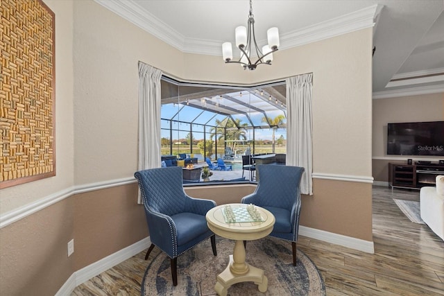 sitting room featuring crown molding, wood-type flooring, and a notable chandelier