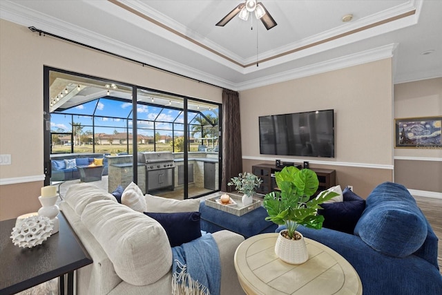 living room featuring hardwood / wood-style floors, a tray ceiling, and ornamental molding