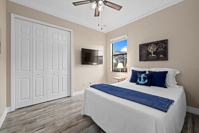 bedroom featuring ceiling fan, hardwood / wood-style floors, a closet, and ornamental molding