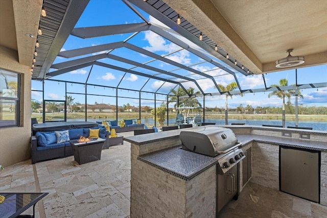 view of patio / terrace with a lanai, an outdoor kitchen, outdoor lounge area, area for grilling, and a water view