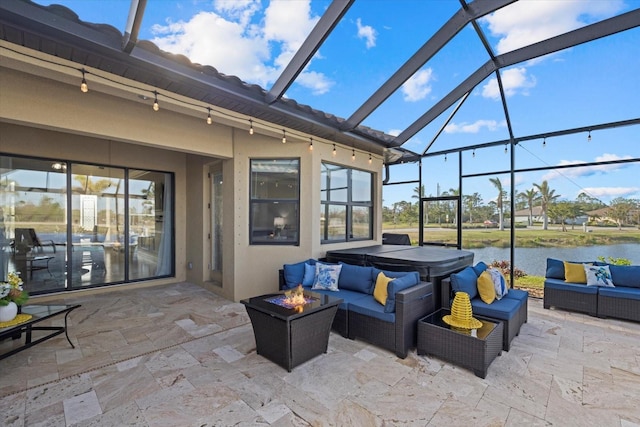 view of patio featuring glass enclosure, an outdoor living space with a fire pit, and a water view