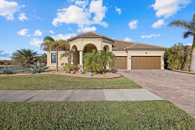 mediterranean / spanish-style house featuring a garage and a front yard