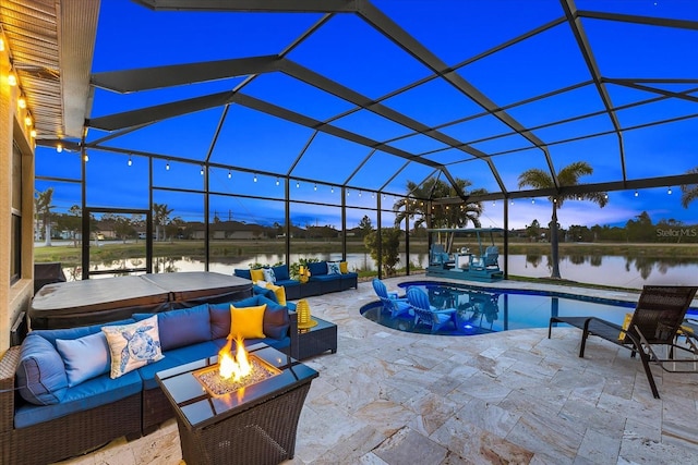 pool at dusk with a lanai, an outdoor living space with a fire pit, a hot tub, a water view, and a patio