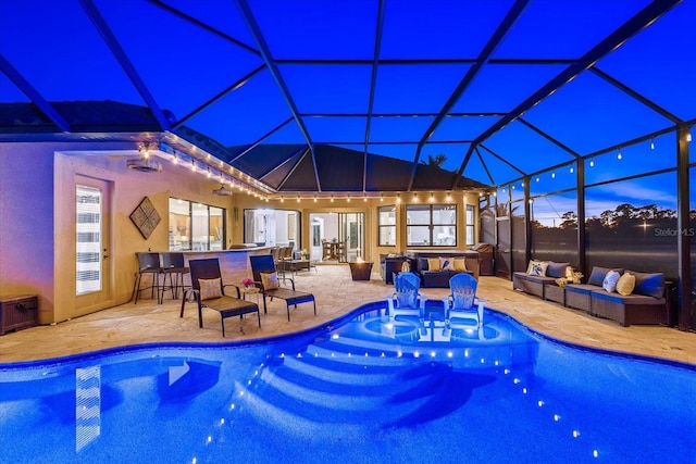 pool at dusk featuring glass enclosure, a hot tub, a patio area, outdoor lounge area, and an outdoor bar