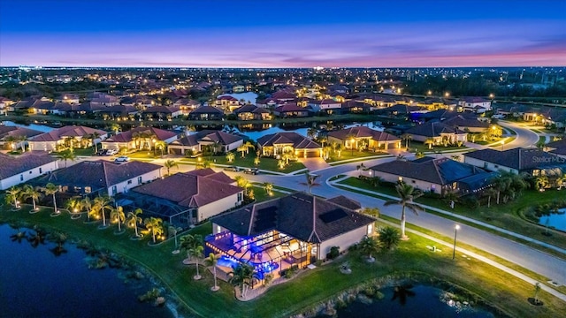 aerial view at dusk featuring a water view