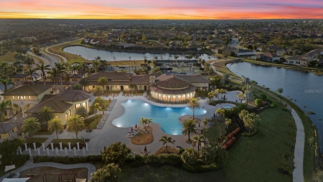 aerial view at dusk featuring a water view