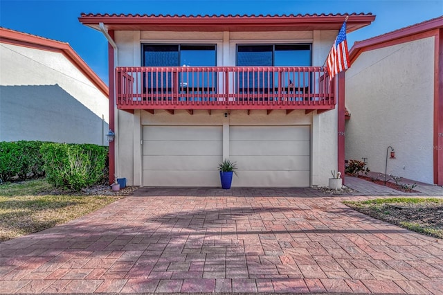 view of front of home featuring a balcony and a garage