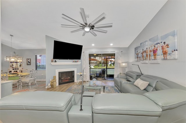 living room with lofted ceiling, ceiling fan, and light hardwood / wood-style flooring