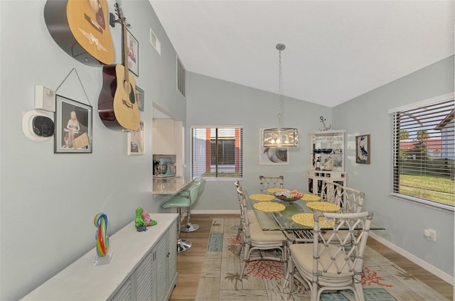 dining area featuring vaulted ceiling and light hardwood / wood-style flooring