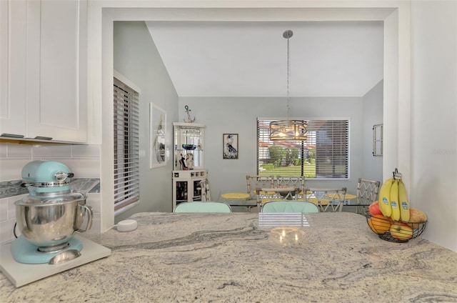 dining area with lofted ceiling and a chandelier