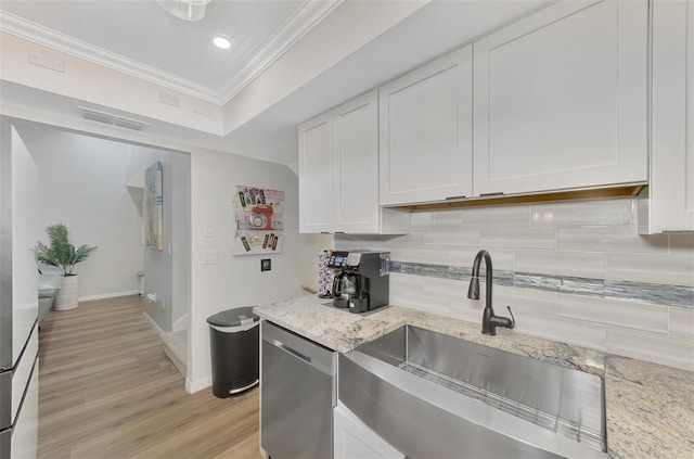 kitchen featuring sink, white cabinets, light stone counters, stainless steel dishwasher, and crown molding