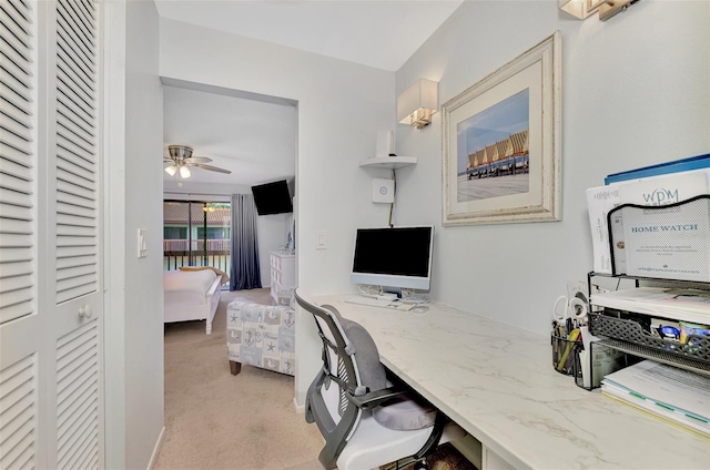 carpeted home office featuring ceiling fan