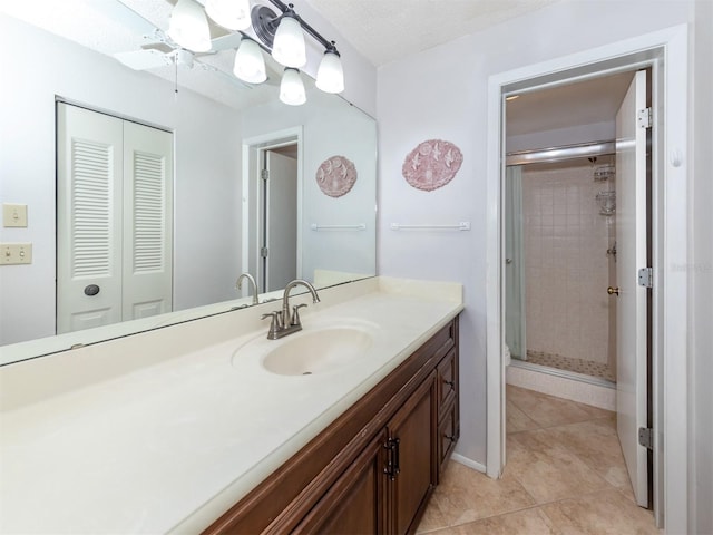 bathroom featuring ceiling fan, tile patterned floors, a textured ceiling, vanity, and a shower with shower door