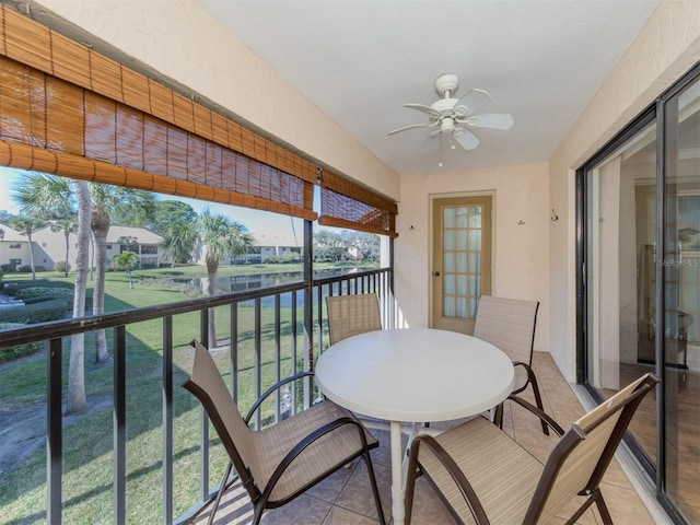 balcony with a water view and ceiling fan