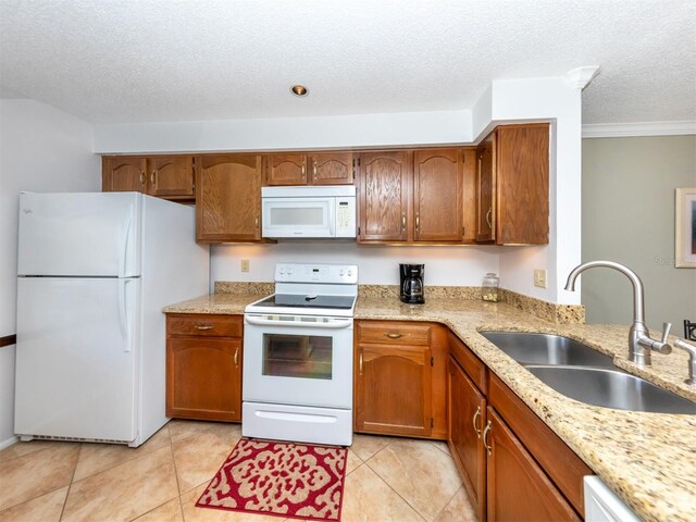 kitchen with white appliances, sink, light tile patterned floors, a textured ceiling, and ornamental molding