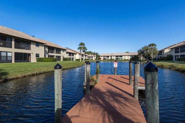 view of dock featuring a yard and a water view