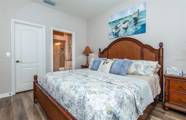 bedroom featuring connected bathroom and dark hardwood / wood-style floors