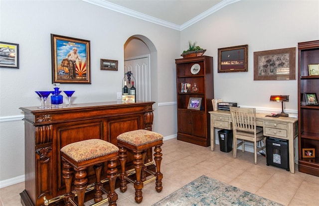 interior space with crown molding, bar, vaulted ceiling, and light tile patterned floors