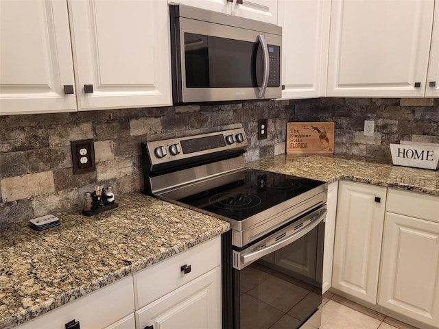201 Auburn Woods Cir, Venice, FL 34292 - kitchen featuring stainless steel appliances, backsplash, white cabinetry, light tile patterned flooring, and stone countertops